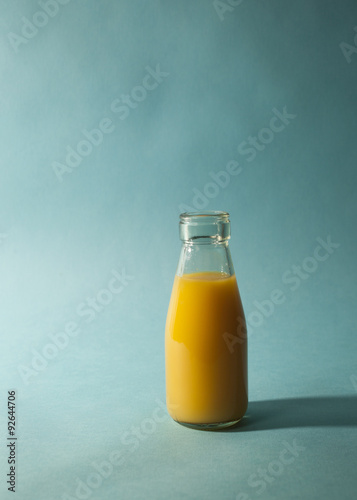Glass of Orange Juice on Teal Background