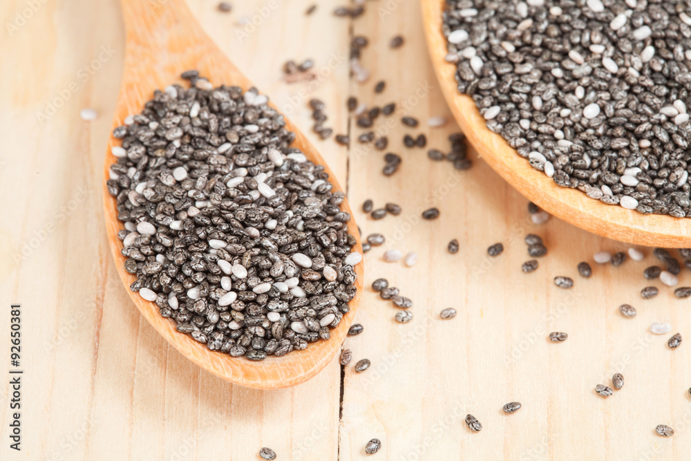 chia seeds in wooden spoon on wood table chia seeds in wooden spoon on wood table