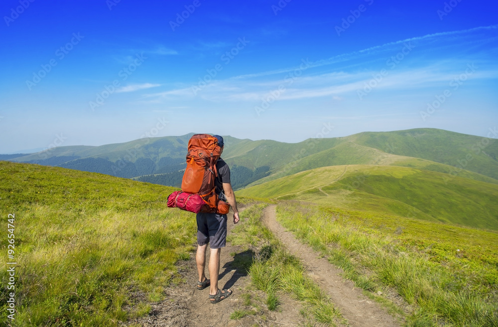 Man with backpack hiking in mountains