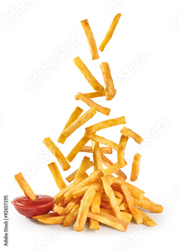 Foto Flying fried potatoes and ketchup isolated on white background.