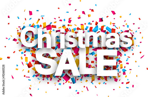 Christmas sale paper sign over confetti.