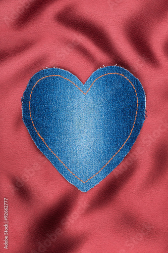 Heart of denim fabric with yellow stitching on red silk