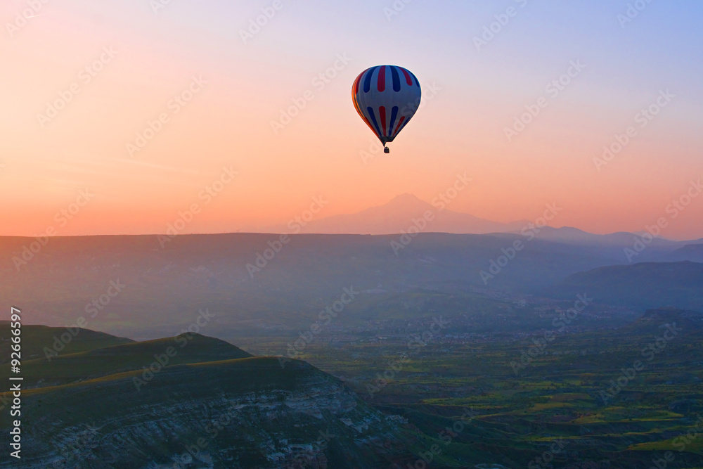 Hot air balloon flying over amazing landscape at sunrise, Cappad