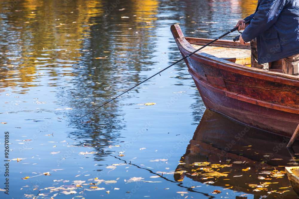 Fisherman fishing with wooden boat