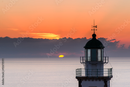 Lighthouse on sunset in Greece