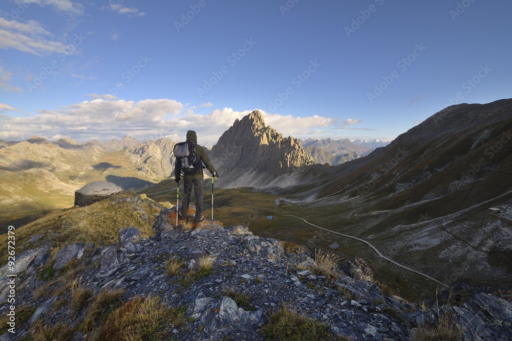 hiker with backpacking observes the Alps, Piedmont, Italy