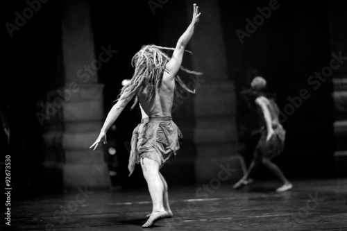 Emotional contemprorary dance; a male dancer with dreadlocks running on stage photo