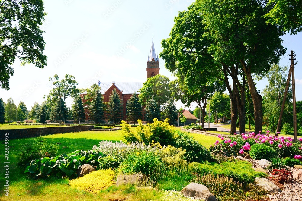 Fototapeta Church and garden in Viesintos town Anyksciai district
