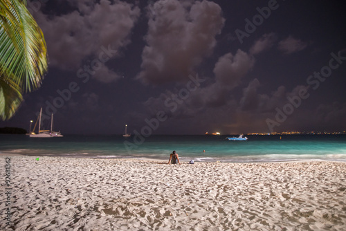 Plage de la Datcha, Le Gosier, Guadeloupe, la nuit, éclairée, une femme posée sur le sable