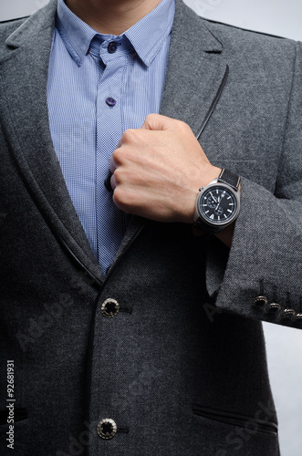 man in a suit shows a wristwatch