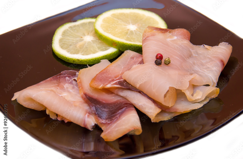 Smoked swordfish on black plate on a white background seen close Smoked swordfish on black plate on a white background seen close