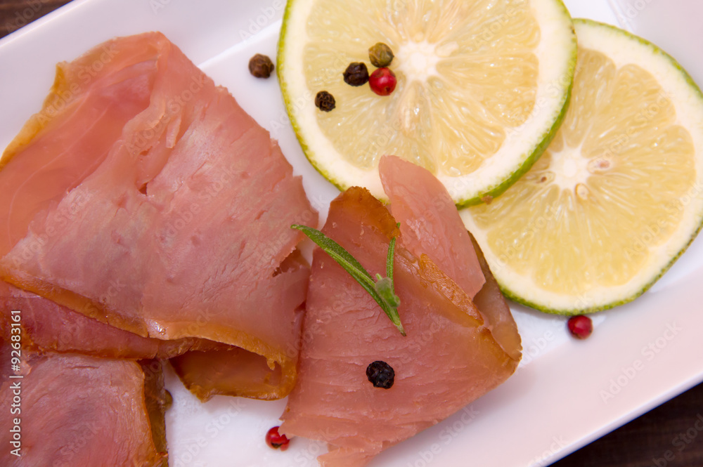 Smoked tuna on tray on wooden table seen from above and close