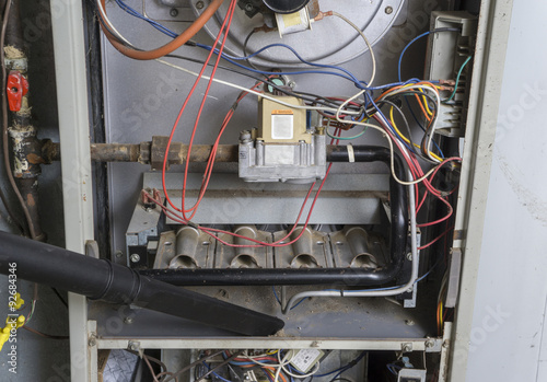 Repairman Vacuuming Inside Of A Gas Furnace © indyedge