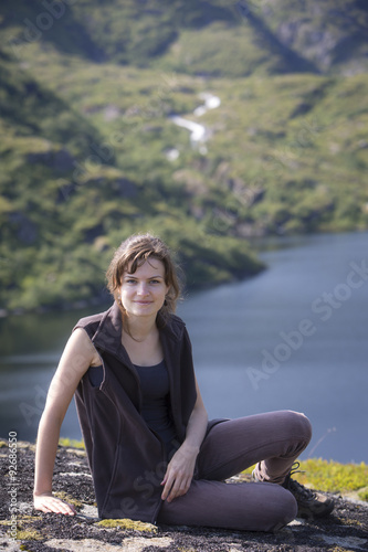 junge Frau rastet an einem Bergsee auf den Lofoten, Norwegen