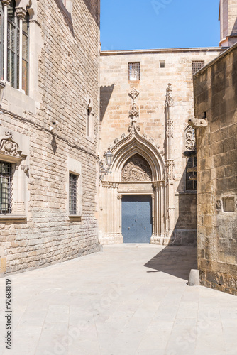 Fototapeta Naklejka Na Ścianę i Meble -  Side entrance to the Cathedral La Catedral de la Santa Creu i Santa Eulalia in the world famous Barri Gotic Barcelona. It is seat of the Archbishop. The cathedral was constructed from the 13th to 15th