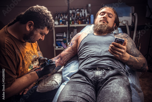 Tattooer makes cool tattoo in tattoo parlor