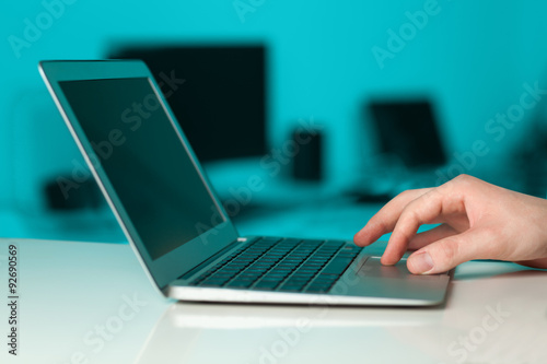 Businessman pressing modern laptop computer on colorful backgrou