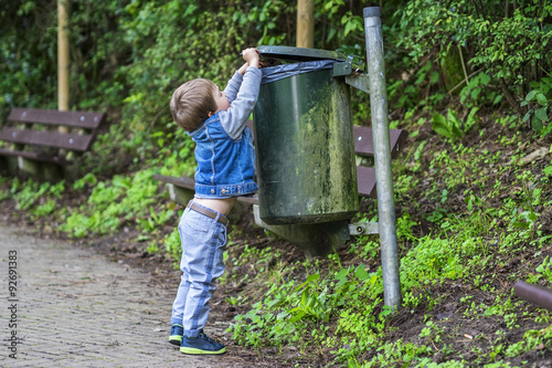 Little boy throwing trash in the bin