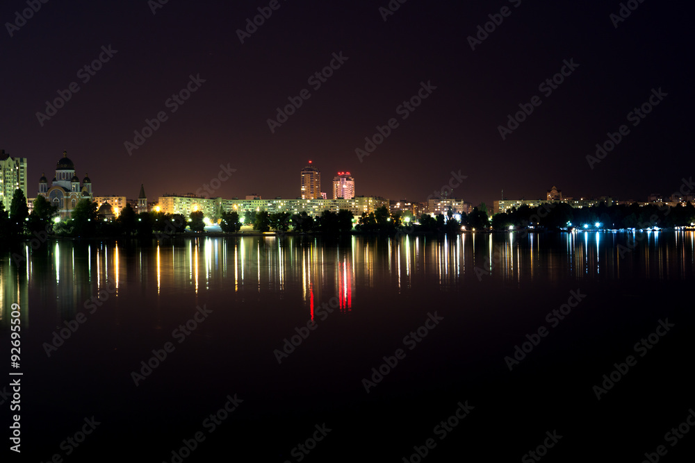 Lights of night city mall with reflections on the river