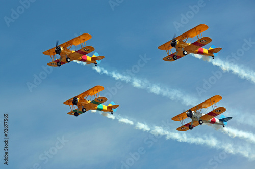 Four Biplanes Flying in Formation with Smoke photo