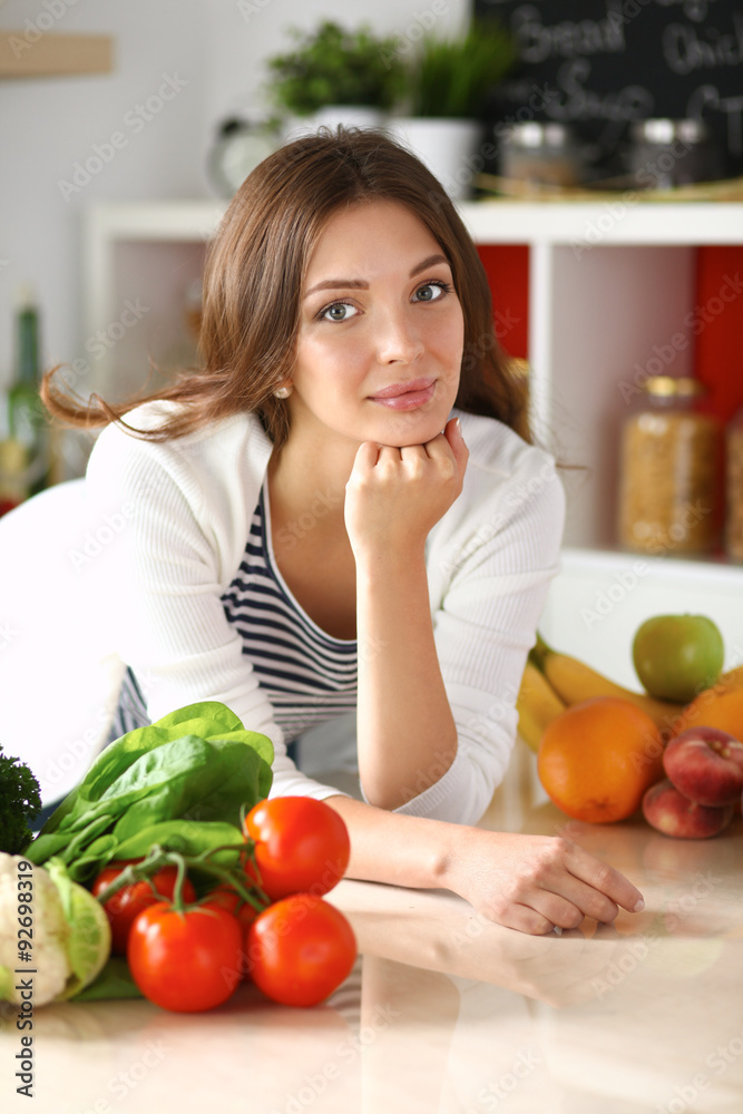 Young woman sitting near desk in the kitchen Young woman sitting near desk in the kitchen