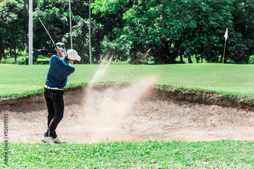 Yong asian golfer explosion sand.