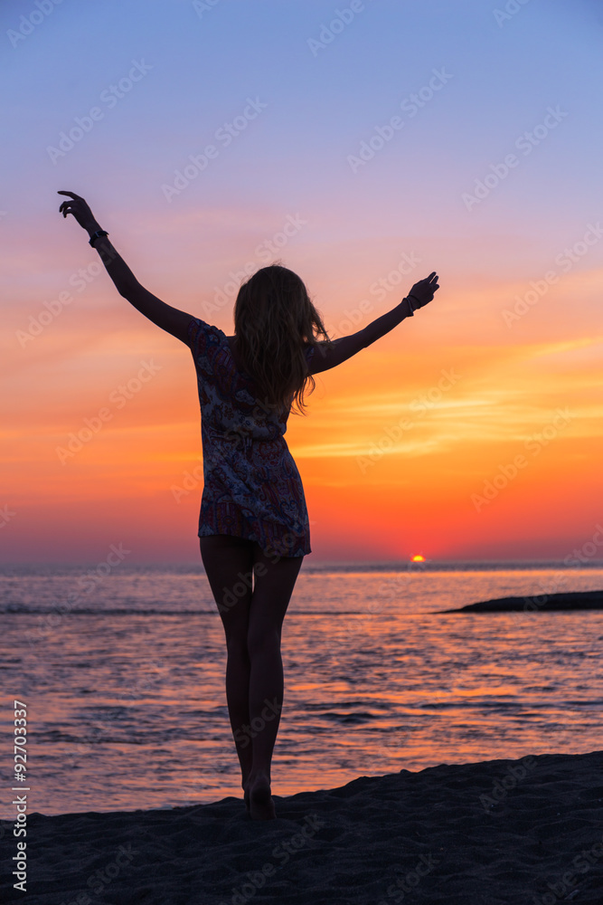 Beautiful young woman on the beach sunset