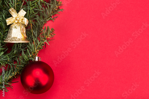 Simple red Christmas background with fir tree   ornaments and bell