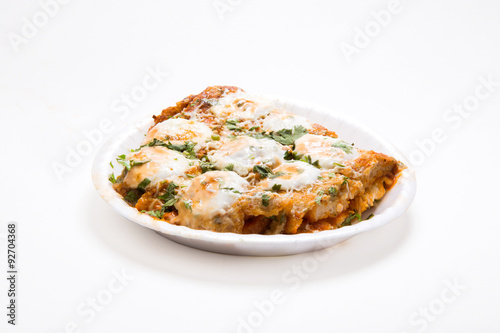 an indian dish Tandoori Omlette in which bread is rolled between an omlette and slightly baked then topped with mayonnaise and cheese isolated on white background available with clipping mask