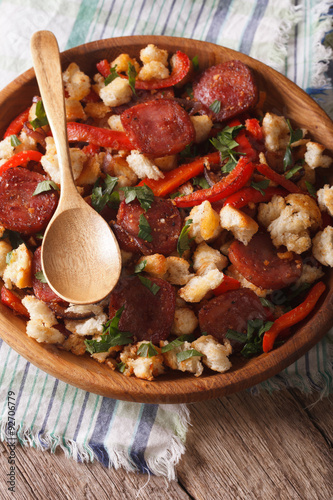 migas with chorizo, bread crumbs and vegetables close-up, vertical