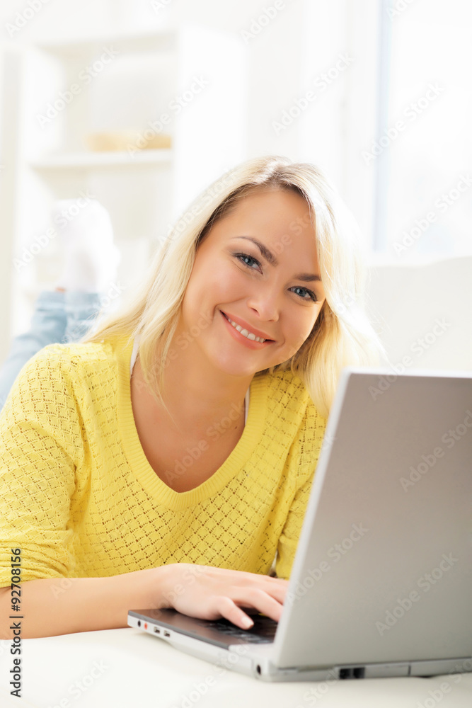 Beautiful blond woman with a laptop computer at home Beautiful blond woman with a laptop computer at home