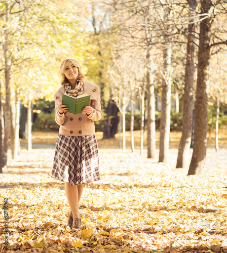 Beautiful woman being alone in the autumn park with a book. © Acronym