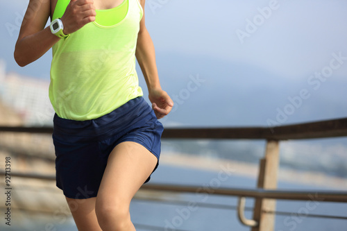 fitness sports woman running on wooden boardwalk seaside