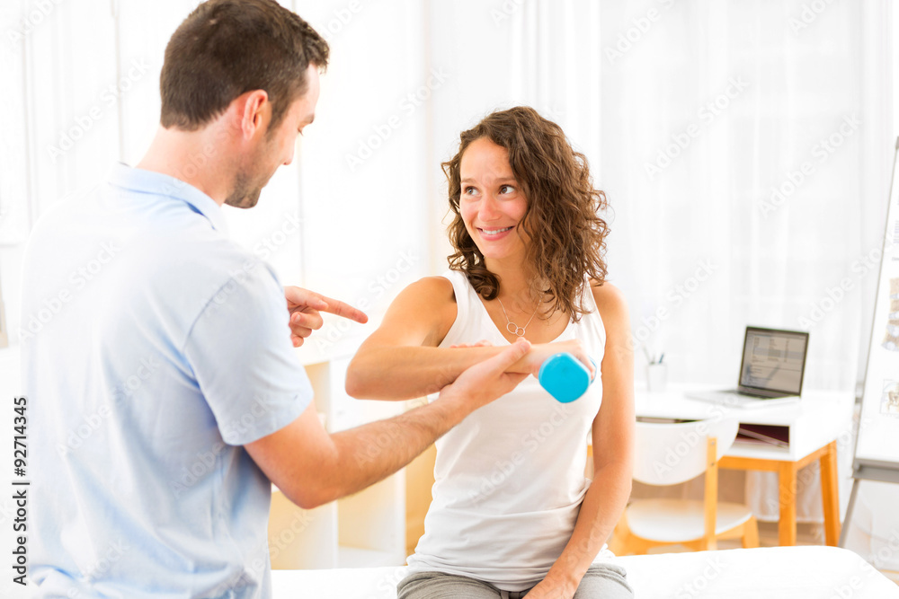 Young attractive woman doing exercise with physiotherapist Young attractive woman doing exercise with physiotherapist