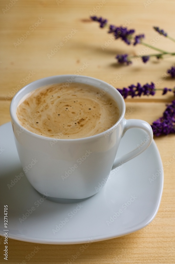 Cup of coffee with cream on light table