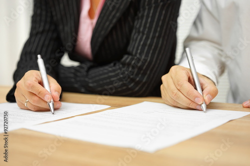 Tableau sur toile businesswoman and businessman signing contract in the office