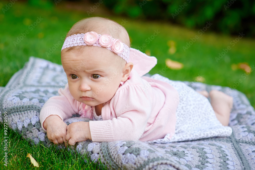 beautiful little baby girl is lying on a plaid blanket beautiful little baby girl is lying on a plaid blanket