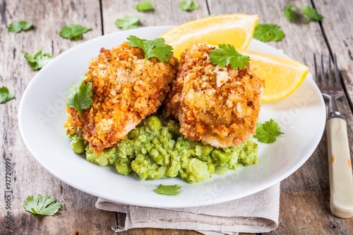 Baked cod fish in breadcrumbs with mashed green peas and broccoli