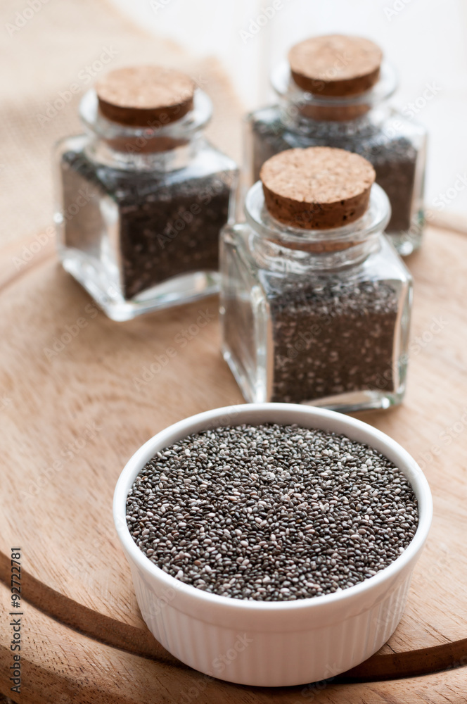 heap of chia seeds, on wooden board heap of chia seeds, on wooden board