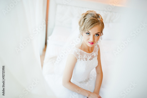 gentle blonde bride on couch tenderly posed