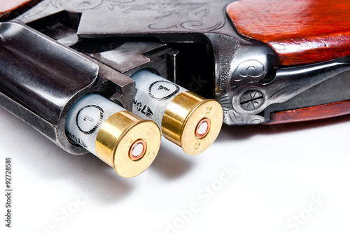 Fotografia Hunting shotgun and ammunition on white background.