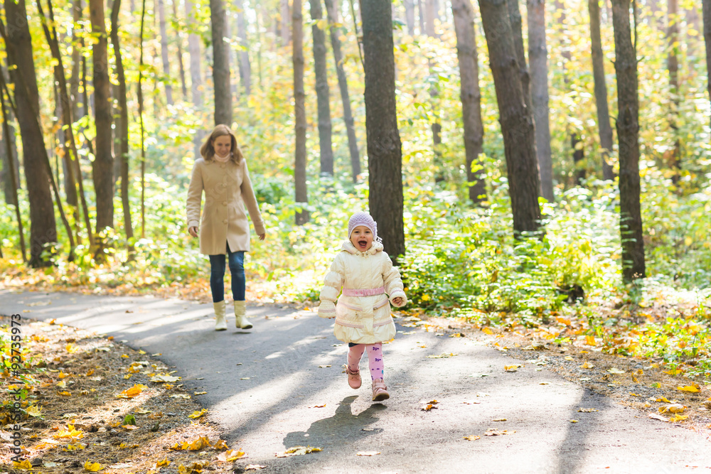 Fototapeta premium Mother and daughter walking in the autumn park