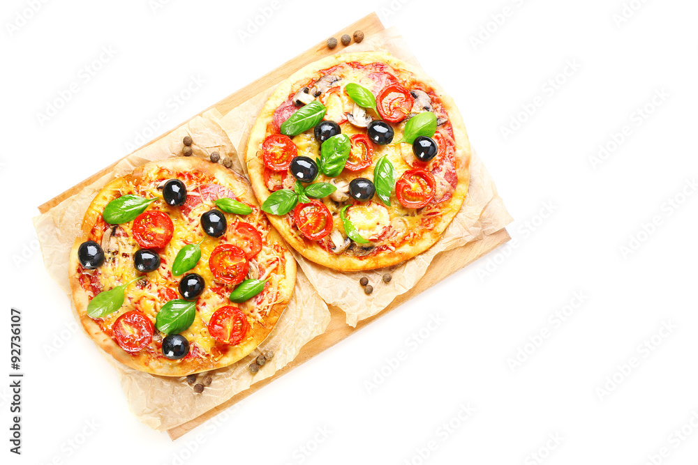 Tasty pizza with vegetables and basil on cutting board isolated on white Tasty pizza with vegetables and basil on cutting board isolated on white