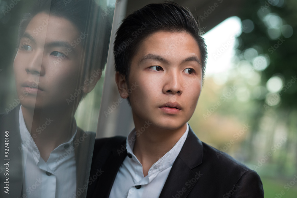 Portrait of chinese elegant businessman near mirroring building Portrait of chinese elegant businessman near mirroring building