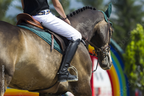 Close up of the rider on a horse during competition matches ridi