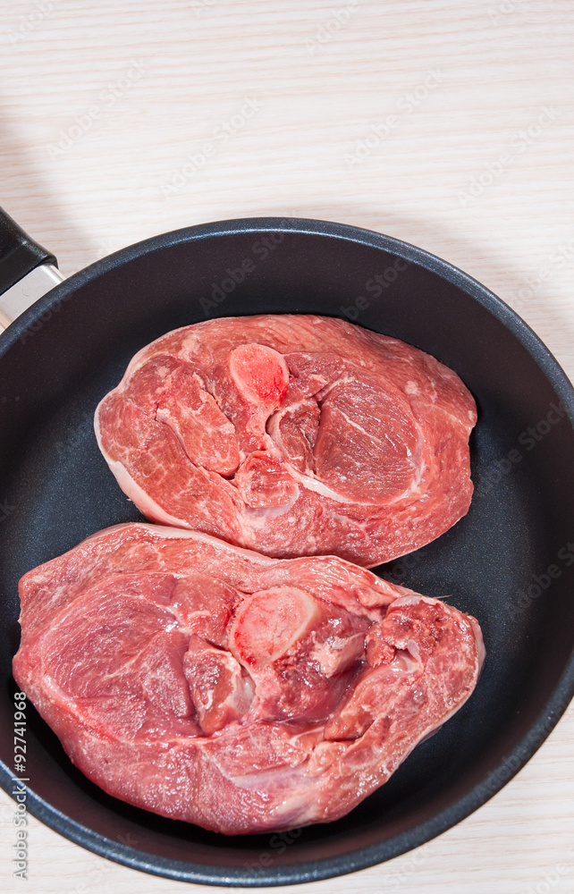 Raw meat in a frying pan Raw meat in a frying pan