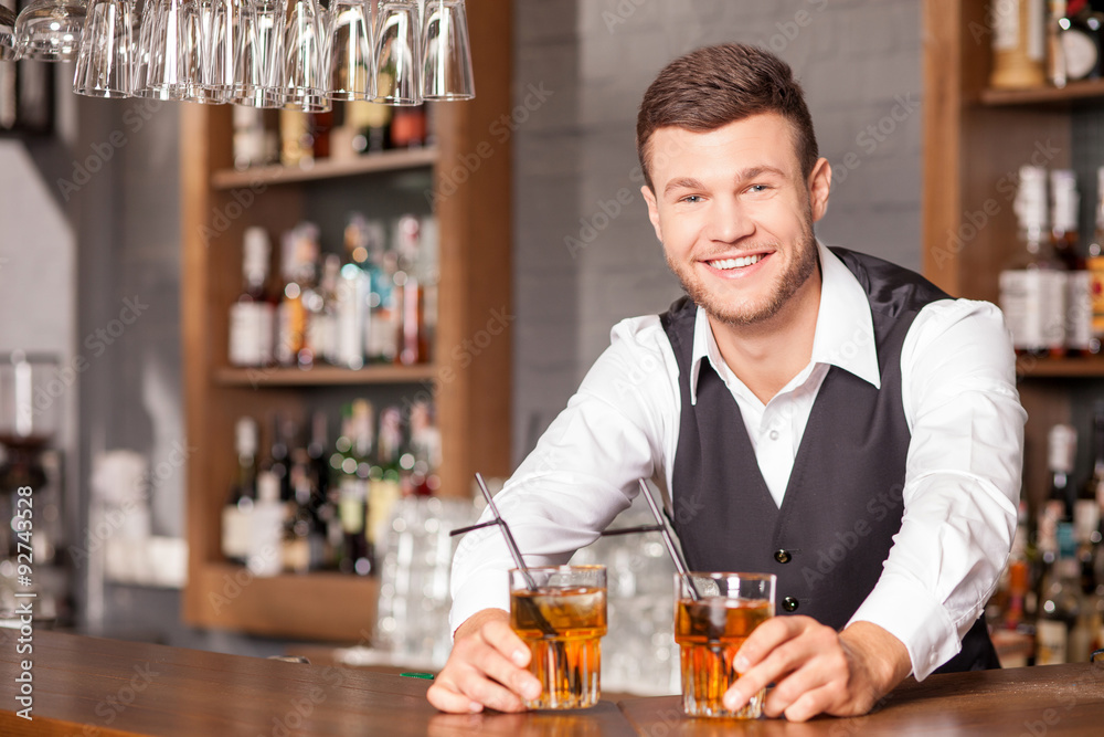 Handsome young bartender is serving his customer