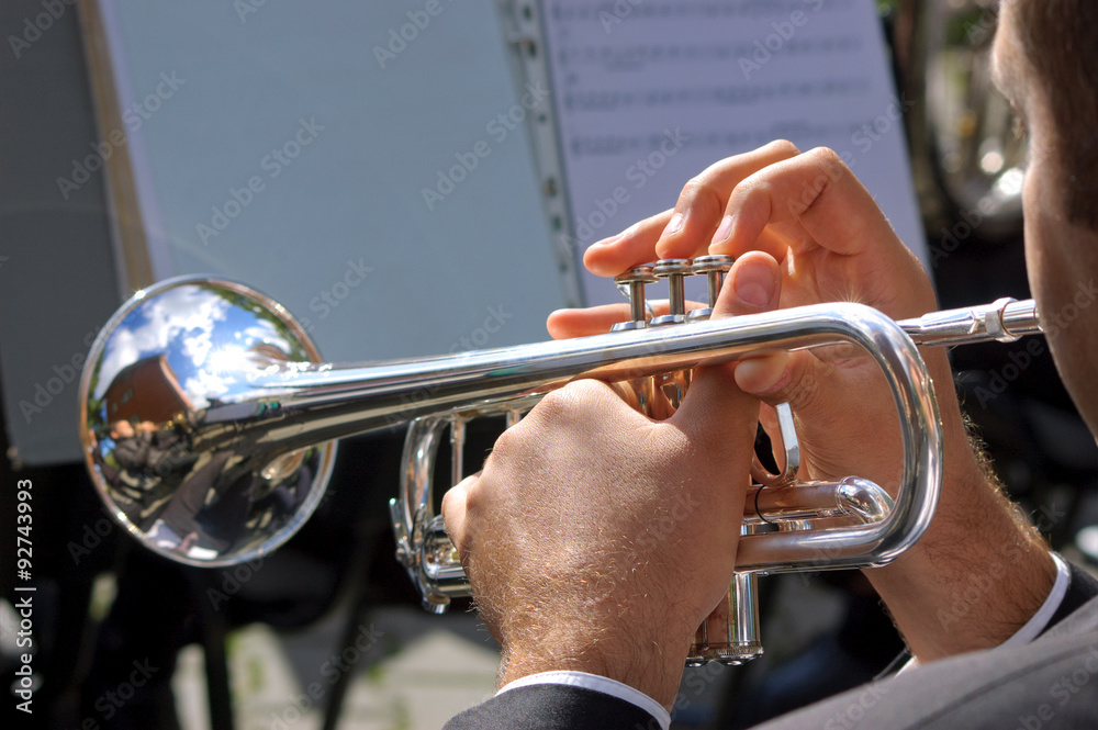 Obraz premium Musician playing on silver trumpet in street orchestra