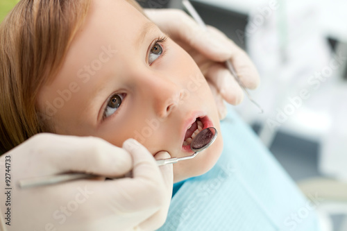 Professional young dentist is treating his small patient