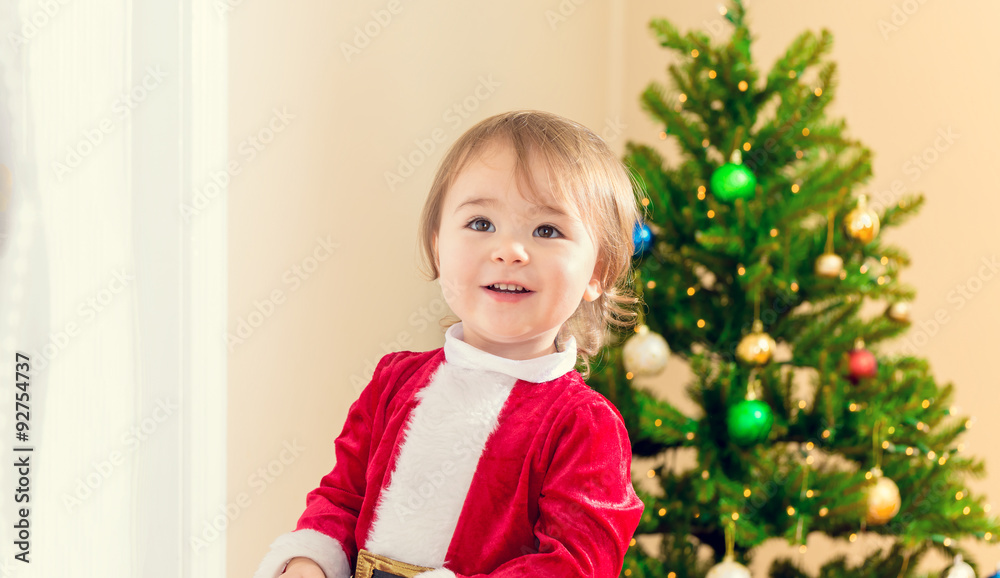 Little toddler girl receiving a candy cane from Santa Claus Little toddler girl receiving a candy cane from Santa Claus